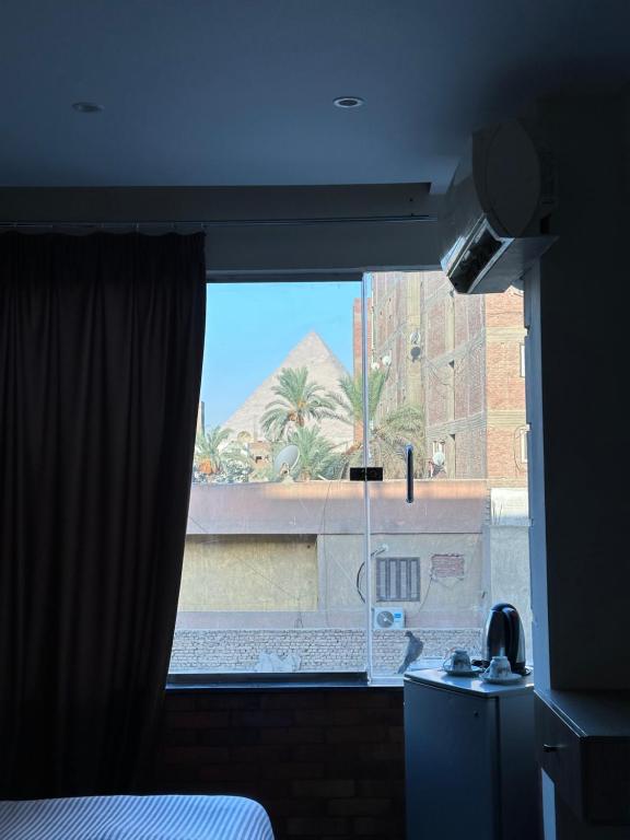 a bedroom window with a view of a building at Atlantis pirámides view Inn in Cairo