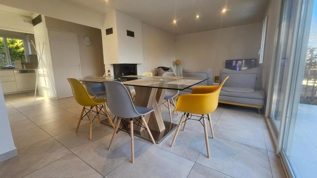 a dining room with a table and yellow chairs at Villa Berninoise in Bernin