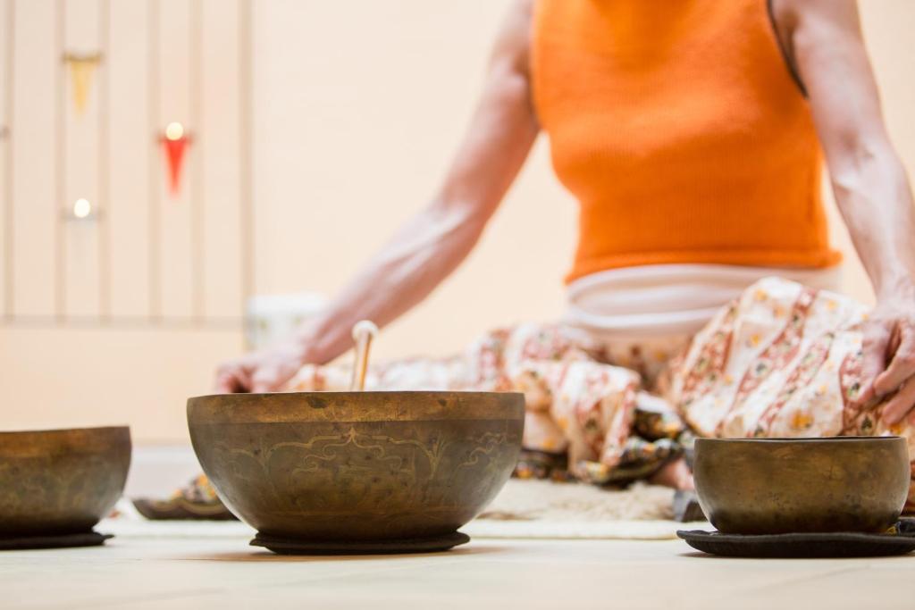 a woman preparing food in a kitchen with bowls on a counter at Hotel Bayernwinkel - Yoga & Ayurveda in Bad Wörishofen