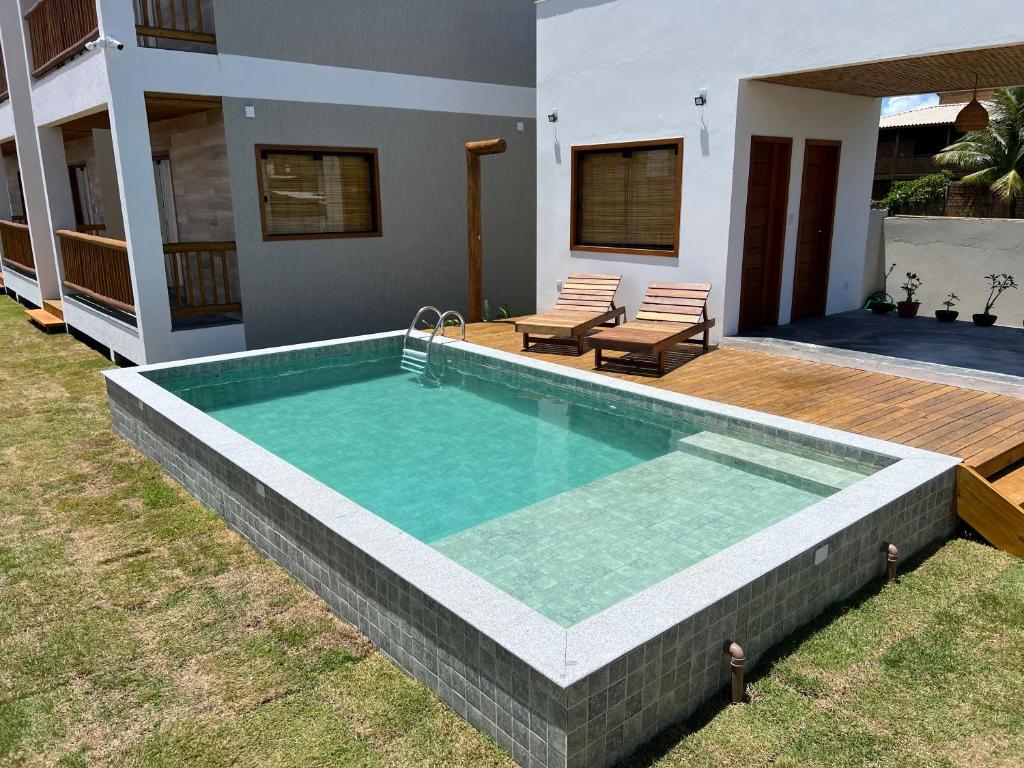 a large swimming pool in a yard with a house at Sol de Marau - Taipu de Fora - próximo das piscinas naturais in Marau