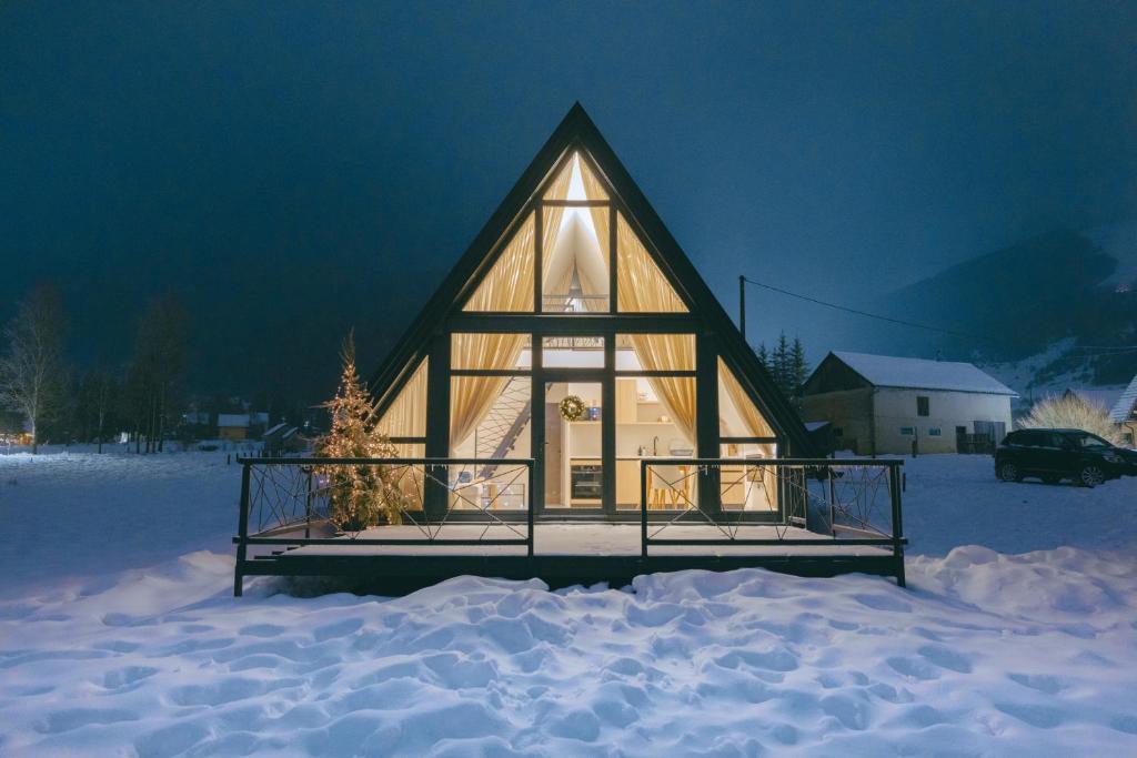 a small cabin in the snow at night at De Villa Bey in Kupres