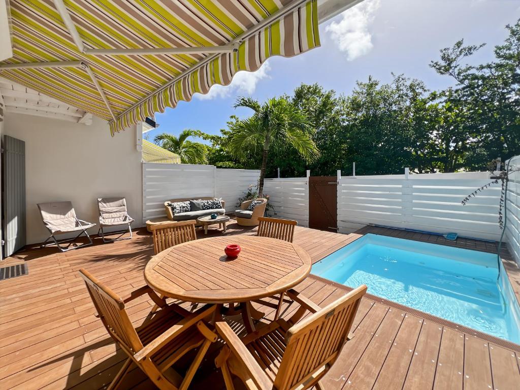 a patio with a table and chairs and a pool at Mango Rouge, 2 bedrooms & pool in Saint Martin