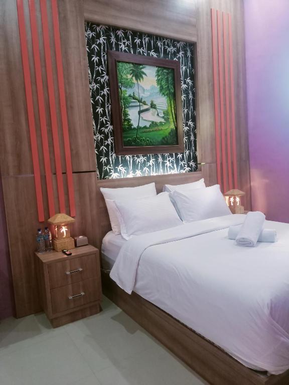 a bedroom with a bed and a picture on the wall at Umah kampung8 in Mataram