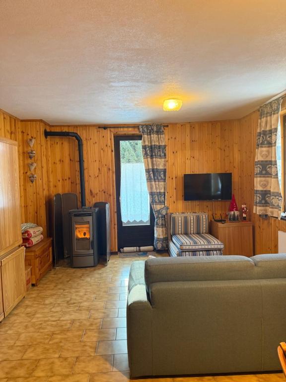 a living room with a couch and a tv at Chalet Nonno Ezio in Valdidentro