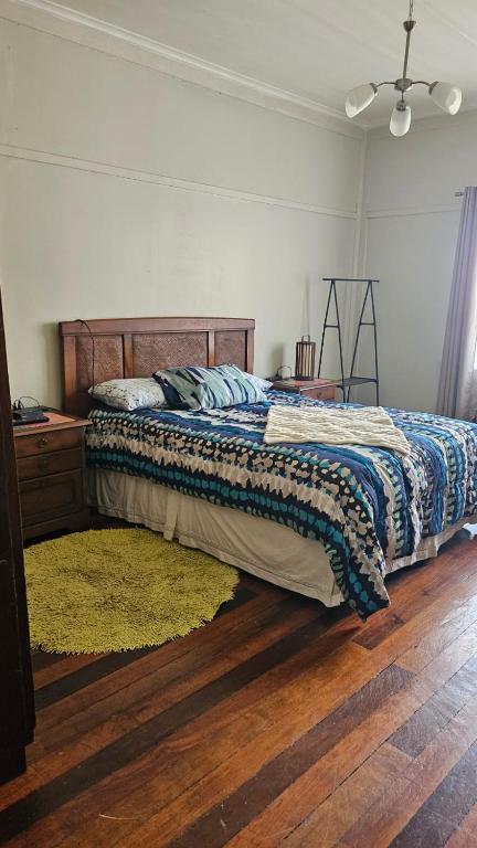 a bedroom with a bed and a wooden floor at Hostel Varas in Viña del Mar