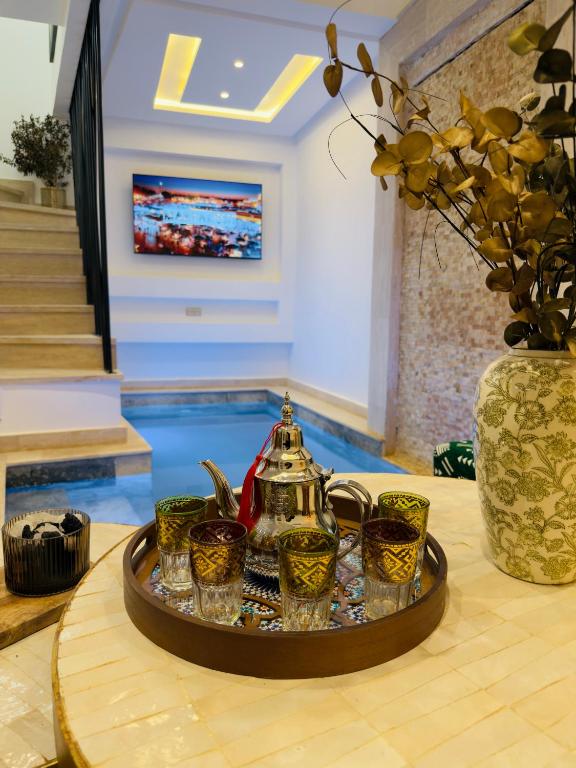 a tray with a tea kettle and cups on a table at RIAD El Ma in Marrakesh