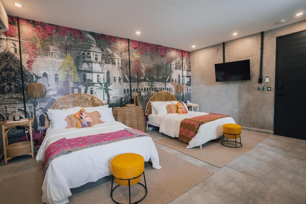 a bedroom with two beds and a mural on the wall at Flor De India in San Juan
