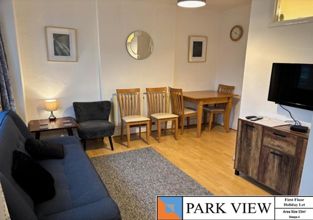 a living room with a couch and a table with chairs at Beckington House in Braunton