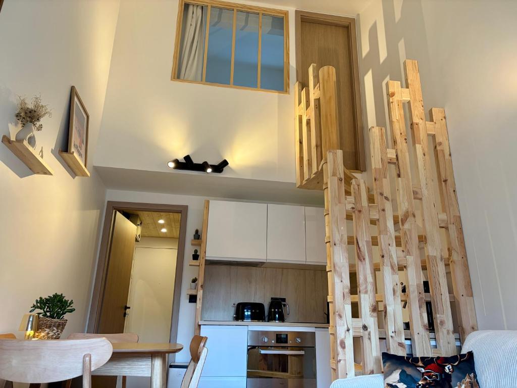a kitchen with a wooden staircase in a room at Charmant duplex Proche station in Aime-La Plagne