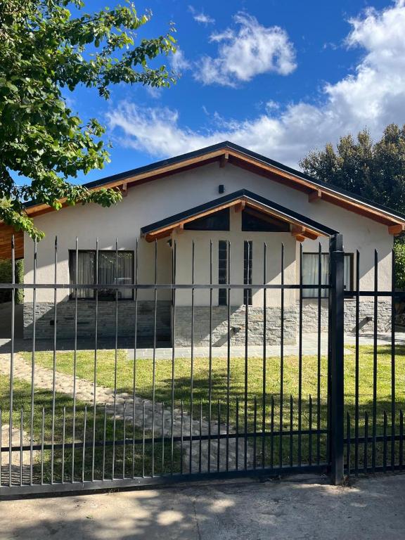 a white building with a fence in front of it at Casa Las Victorias in San Carlos de Bariloche