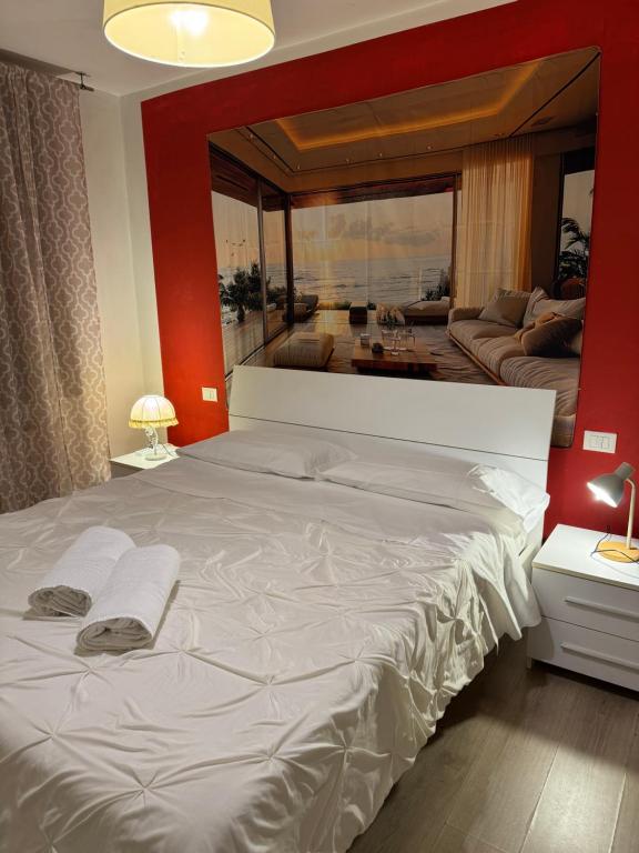 a bedroom with a large white bed with a red wall at Sun Moon Venice Harrysclass in Venice