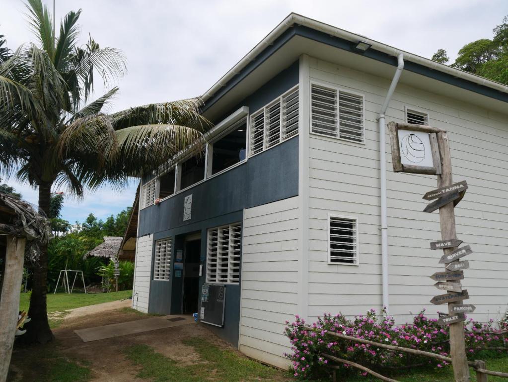 ein weißes Gebäude mit einer Uhr darauf in der Unterkunft Vanuatu Kite & Surfing's Surf Lodge in Port Vila