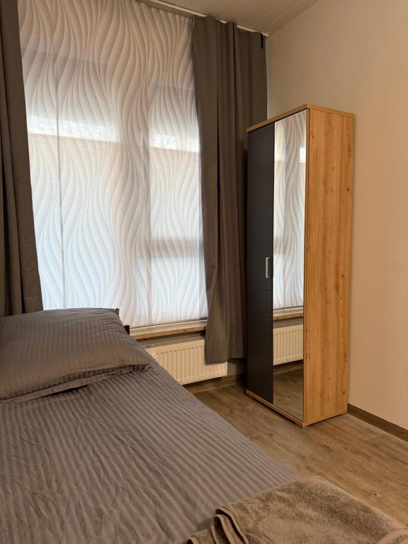 a bedroom with a bed and a dresser next to a window at Hansa Pension 2 Hamburg - Ruhige Zimmer mit Gemeinschaftsküche in Hamburg