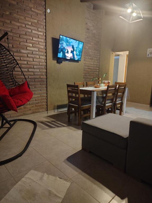 a living room with a table and chairs and a tv at Cabaña Quimey in Villa Rumipal