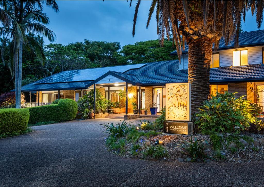 a house with a palm tree in front of it at Mountain Sanctuary Retreat in Mount Tamborine