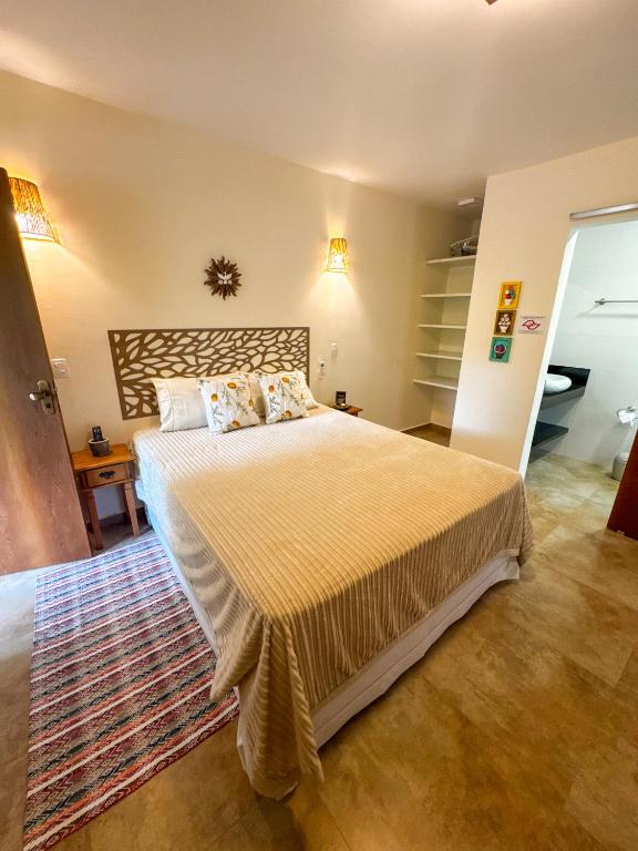ein Schlafzimmer mit einem großen Bett und einem Teppich in der Unterkunft Manduvi in Ilhabela