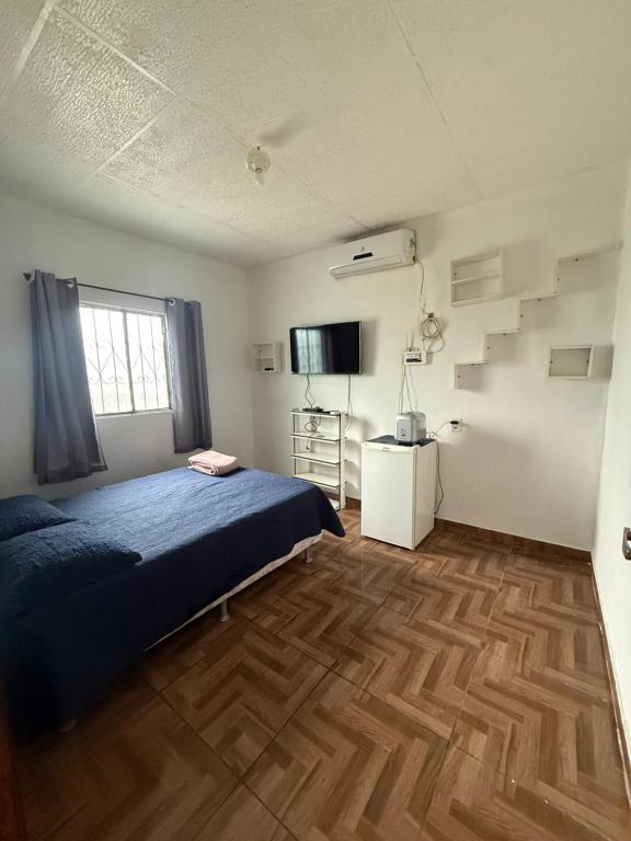 a bedroom with a blue bed and a wooden floor at Recanto do 7 in Presidente Figueiredo