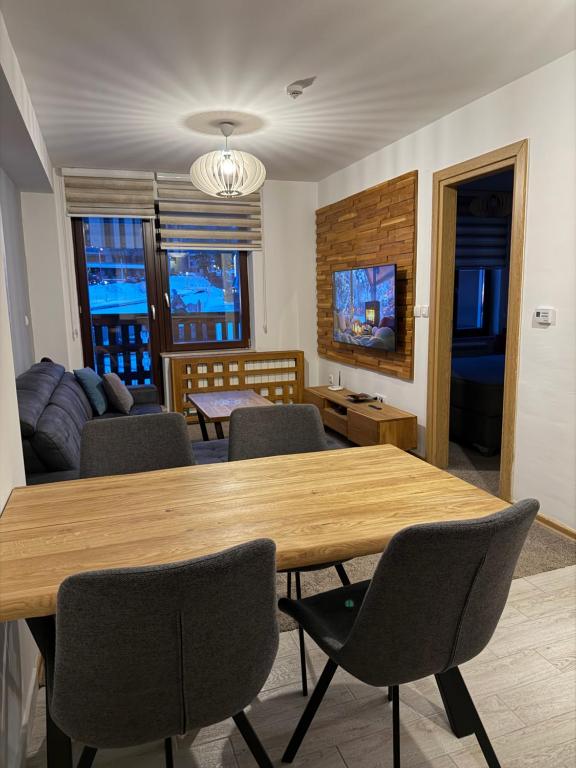 a living room with a wooden table and chairs at Krčma Jahorina in Jahorina