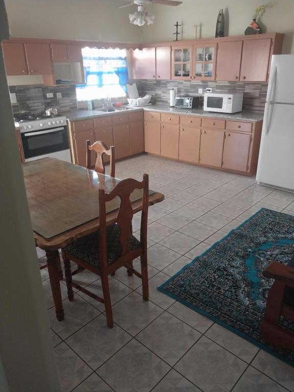 a kitchen with a table and chairs and a refrigerator at LRM Home in Basseterre