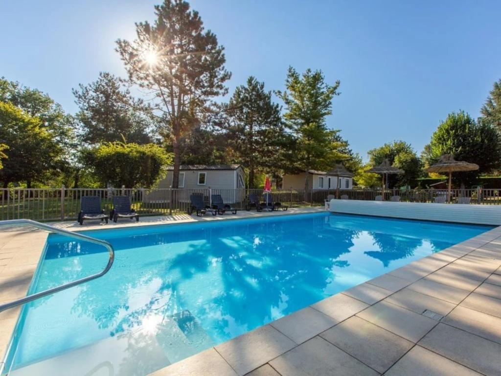 a swimming pool with blue water in a yard at ZEcamping 3 étoiles - bord de Loire - proximité directe des châteaux in Sully-sur-Loire