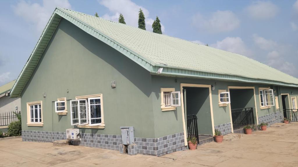 a green house with a green roof at Lakatabu Apartments in Mama