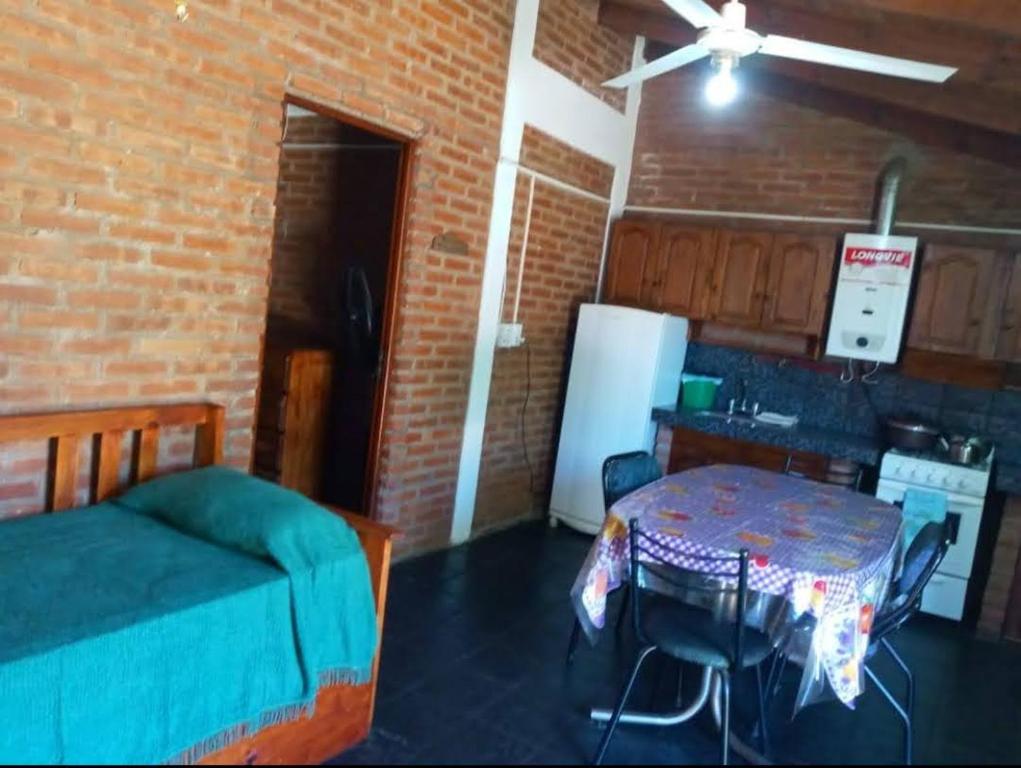 a room with a bed and a table and a kitchen at Mi Niña's in Villa Cura Brochero