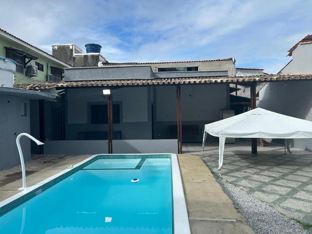 a swimming pool in front of a house at Casa Familiar Ampla - Conforto e Lazer no Frances in Praia do Frances