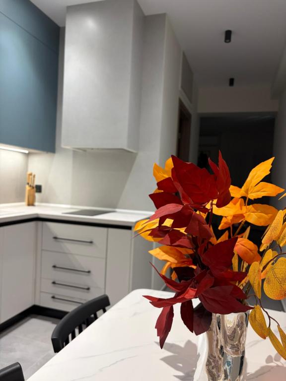 a kitchen with a vase with red and yellow flowers in it at Bright 7th floor Studio-Near Center of Xanthi in Xanthi