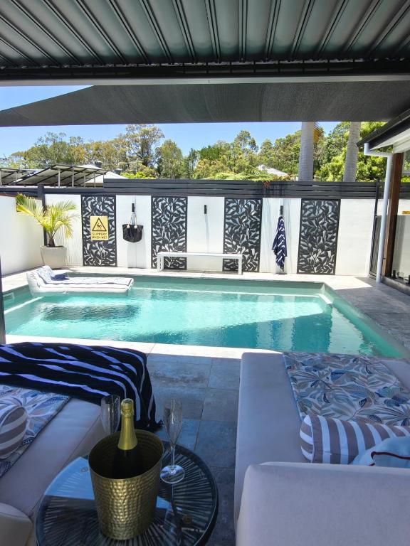 a swimming pool with a table and chairs next to it at Ellie's Holiday Escape - Pool, Romantic, Fireplace in Coffs Harbour