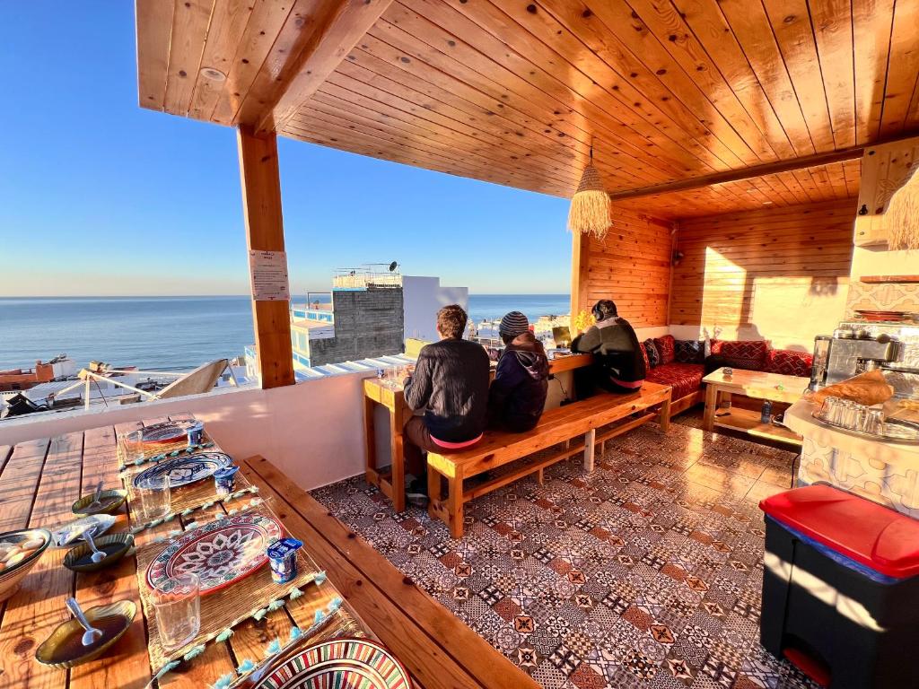 a group of people sitting on a bench in a room at Tawja Surf House in Taghazout