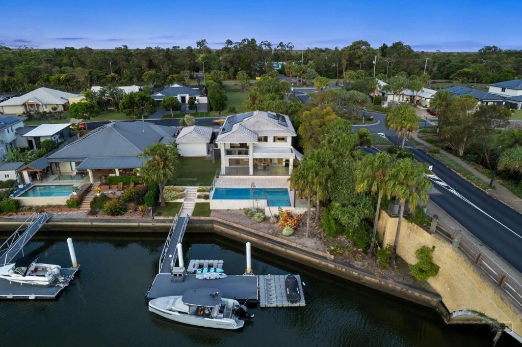 an aerial view of a house with a boat in the water at Maison De Vacances in Banksia Beach
