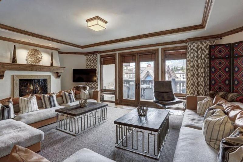 a living room with a couch and a fireplace at Platinum 4 Bedroom Vacation Rental In The Heart Of Vail That Includes Ski Valet, Ski Deck, Rooftop Pool, Panoramic Views in Vail