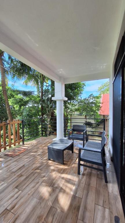 a porch with two benches and a table and chairs at noemi apartments samara beach A-2 in Sámara