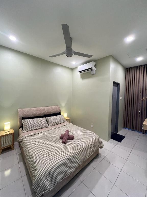 a bedroom with a bed with a teddy bear on it at Amara Homestay Gurun in Kampong Bongkok