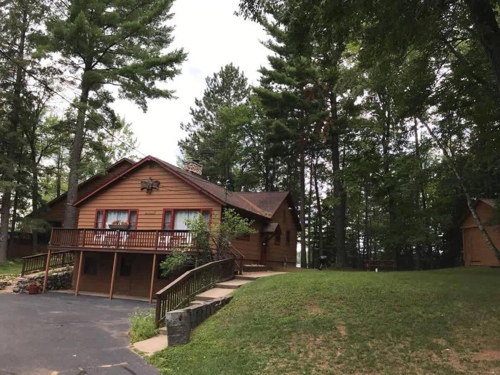 a log cabin with a balcony and a yard at Eagle Villa At Otter Cove in Eagle River