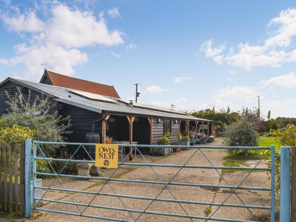 a house with a gate with a sign that reads own nest at Owls Nest in Stradbroke