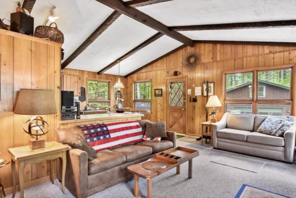 a living room with a couch and a table at Creekside Big St Germain Lake in Saint Germain
