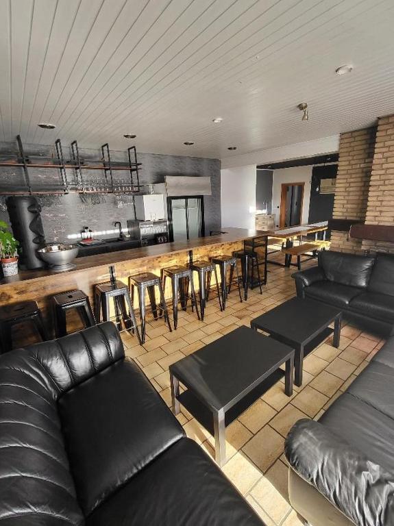 a living room with black leather furniture and a bar at Hani's Partyhaus in Verl