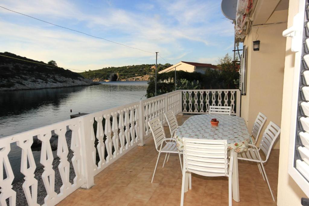 a table and chairs on a balcony with a view of the water at Apartment Rogacic 2460a in Vis