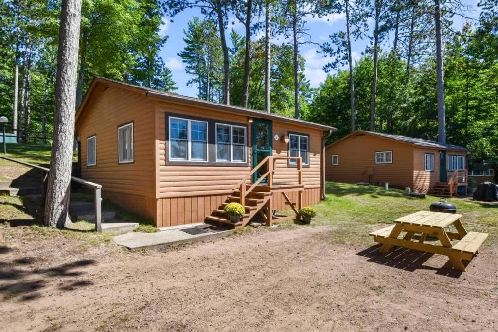 a cabin with a picnic table in front of it at Bayview Resort Waters Edge Cabin 2 in Saint Germain