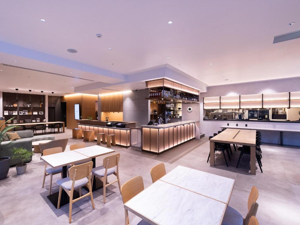 a restaurant with tables and chairs and a bar at Tokyu Stay Sapporo in Sapporo