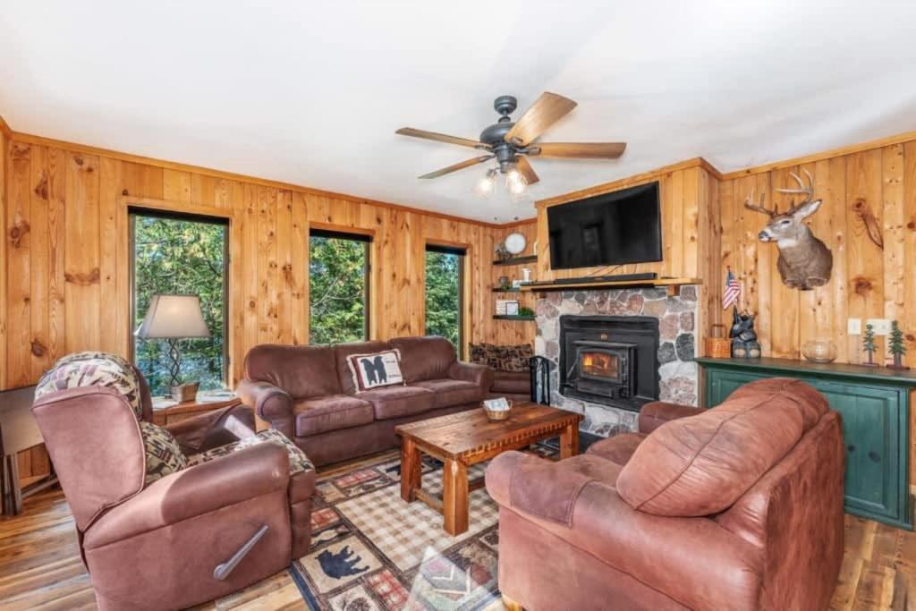 a living room with leather furniture and a fireplace at Clover Pines in Eagle River