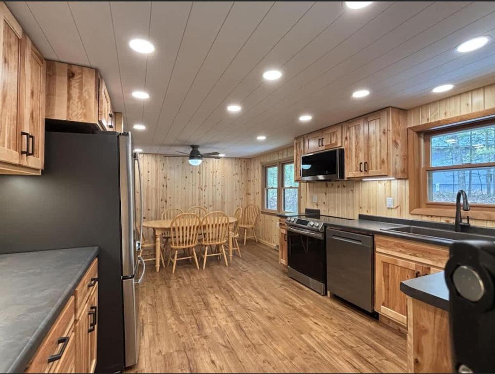 a kitchen with a black refrigerator and a table at Bayview Resort Sunset Lookout Cabin 6 in Saint Germain