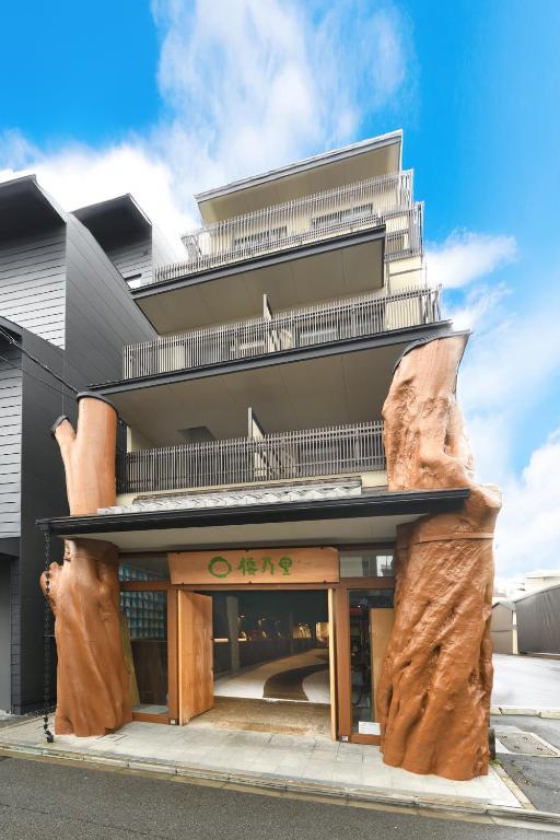 a building with a large wooden building with a large rock at Wanosato Kyoto Musee in Kyoto