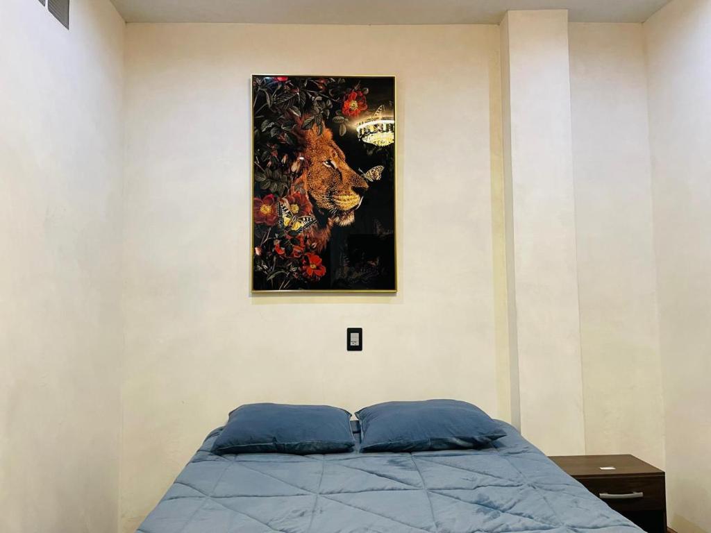 a painting hanging on a wall above a bed at Borde del lago in Panajachel