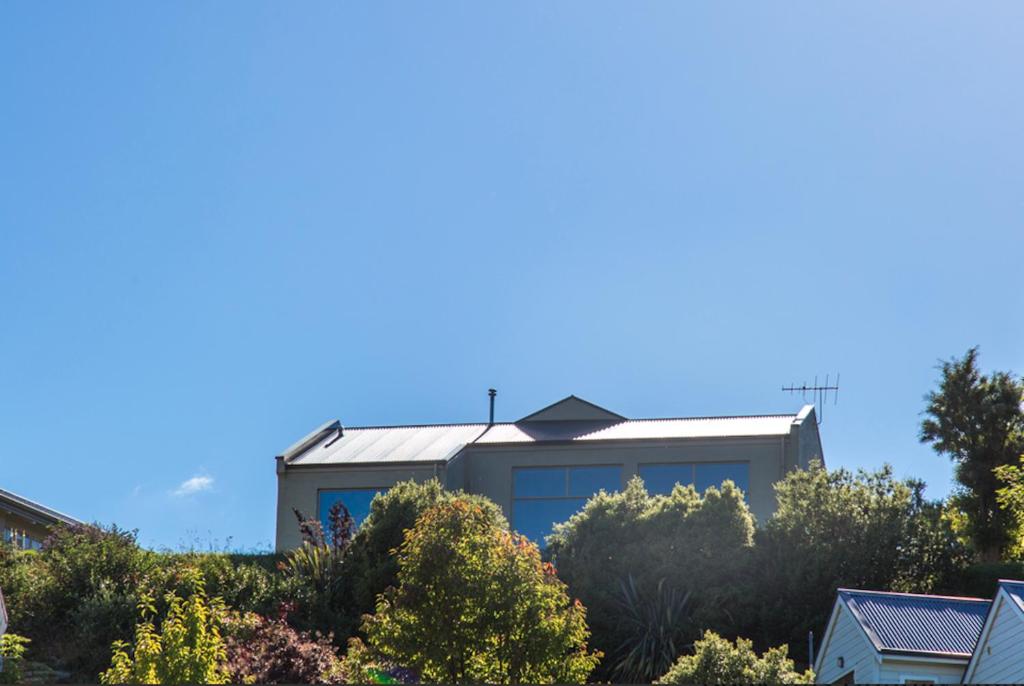 a house on top of a hill with trees at Arrowtown Dress Circle in Arrowtown