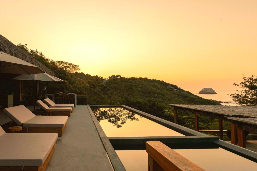 a resort with a pool and a view of the ocean at Casa Yute Boutique Hotel Playa Aragon in San Agustinillo