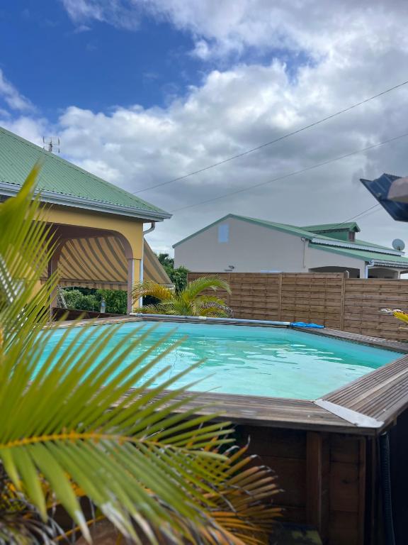 a swimming pool in front of a house at Maison de campagne proche des plages in Sainte-Rose