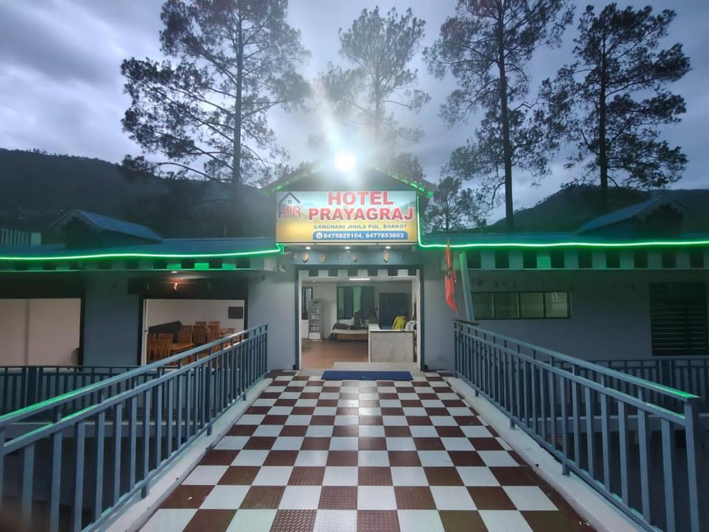 a hotel with a sign on a checkered floor at Hotel prayagraj in Barkot