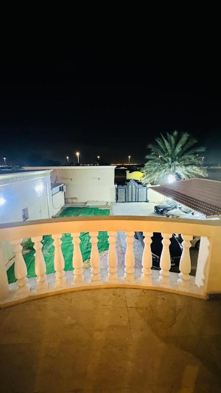 a balcony with a white fence and a palm tree at Suite Room with big balcony in Al Rahba